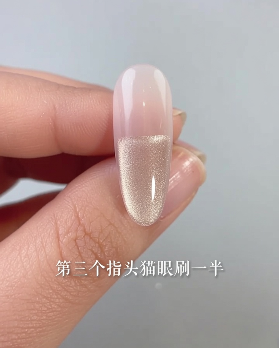 Gros plan dun ongle avec un vernis gel cat-eye appliqué uniquement sur la moitié inférieure de la plaque de longle.
