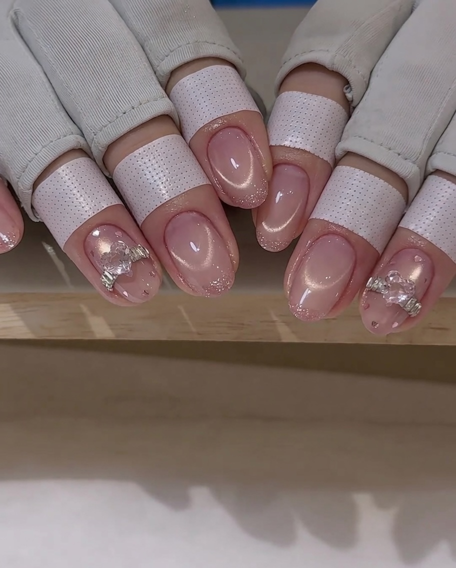 Un pinceau de nail art applique une couche de top coat autour dun charm.