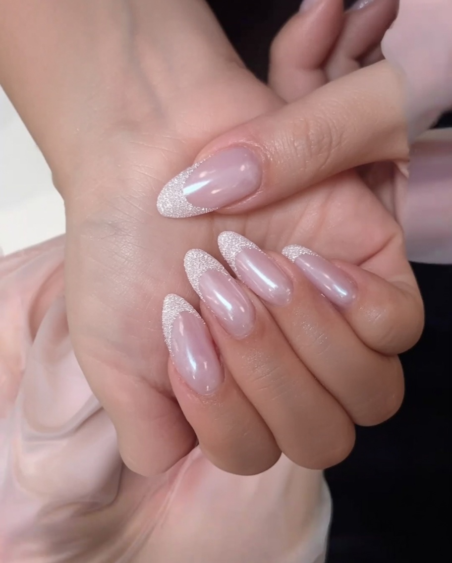 Un coton non pelucheux nettoyant la surface dun ongle nude rosé mat.