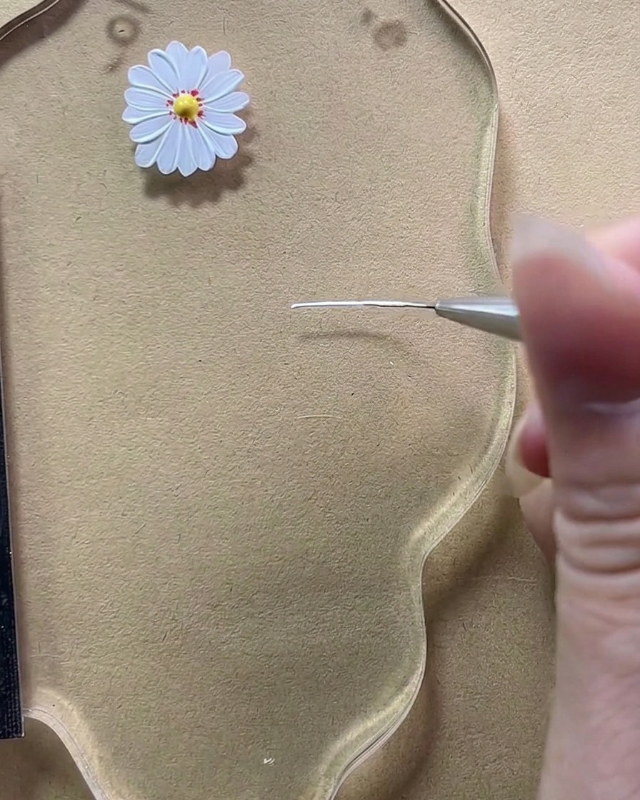 Vue rapprochée dun pinceau fin traçant une courte ligne verticale blanche sur une palette transparente.