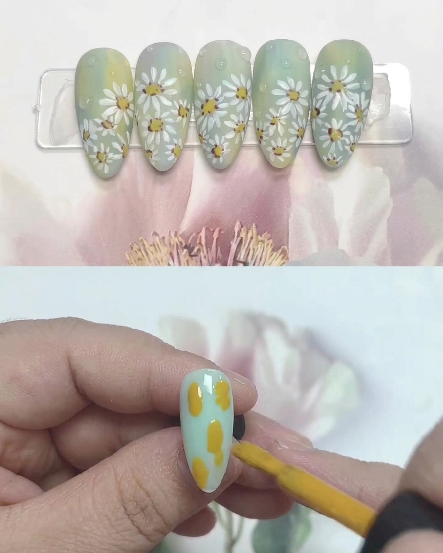 Un pinceau à ongle déposant des taches de gel jaune, bleu et blanc sur une capsule transparente.