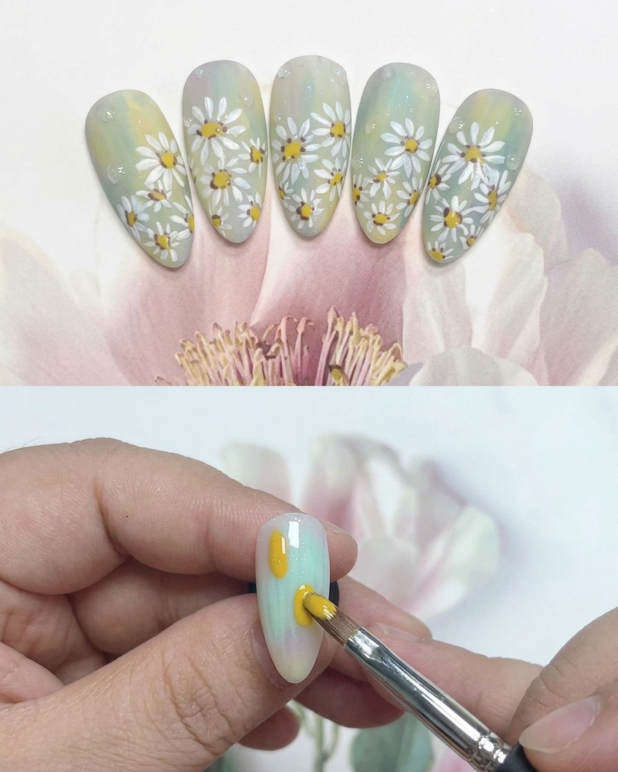 Un pinceau liner fin dessinant des pétales blancs autour dun centre jaune sur un ongle.