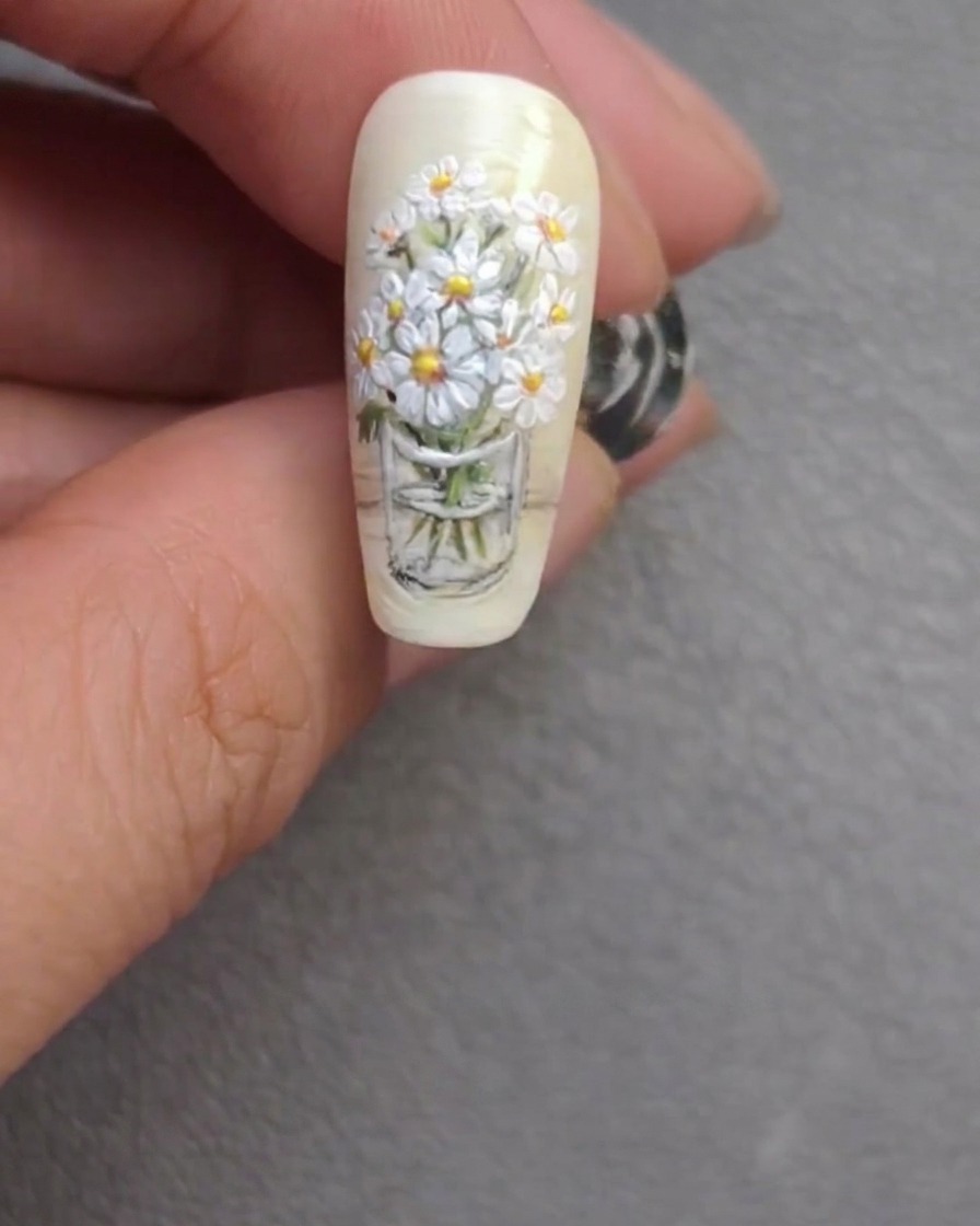 Le nail art fini, mettant en valeur des tiges raffinées et des reflets floraux éclatants.