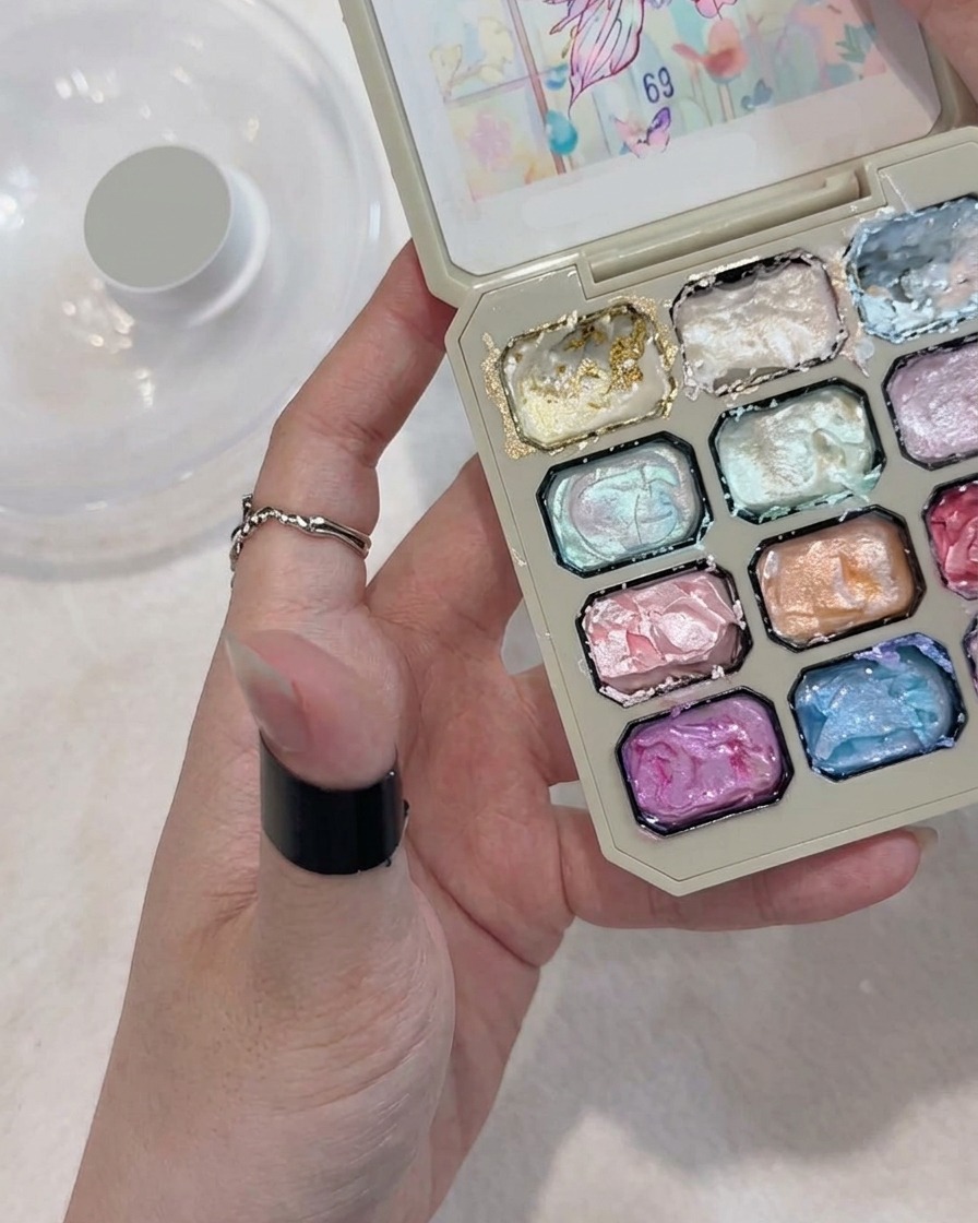 Un pinceau appliquant du gel blanc pour former une fleur à cinq pétales sur un ongle.