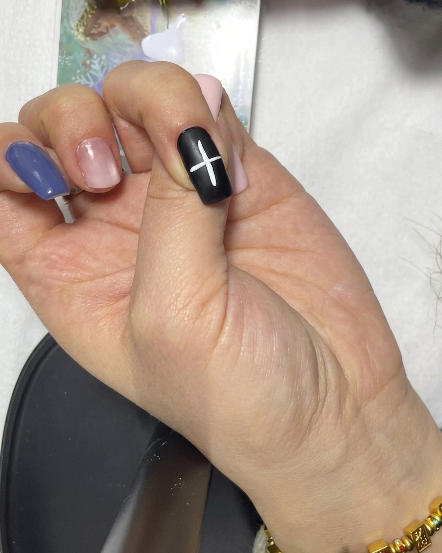 Gros plan dune ligne diagonale ajoutée à la croix existante sur un ongle noir.