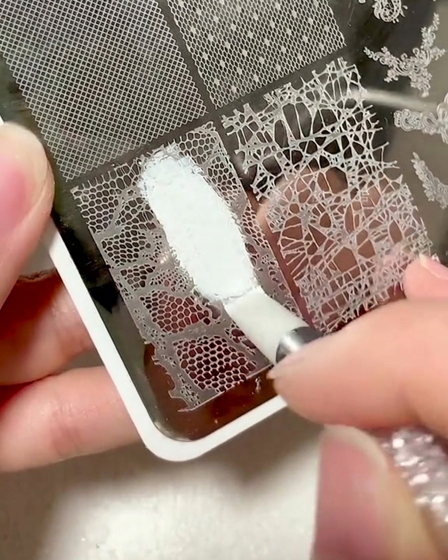 Une raclette en plastique utilisée pour nettoyer lexcès de gel dune plaque destampage.