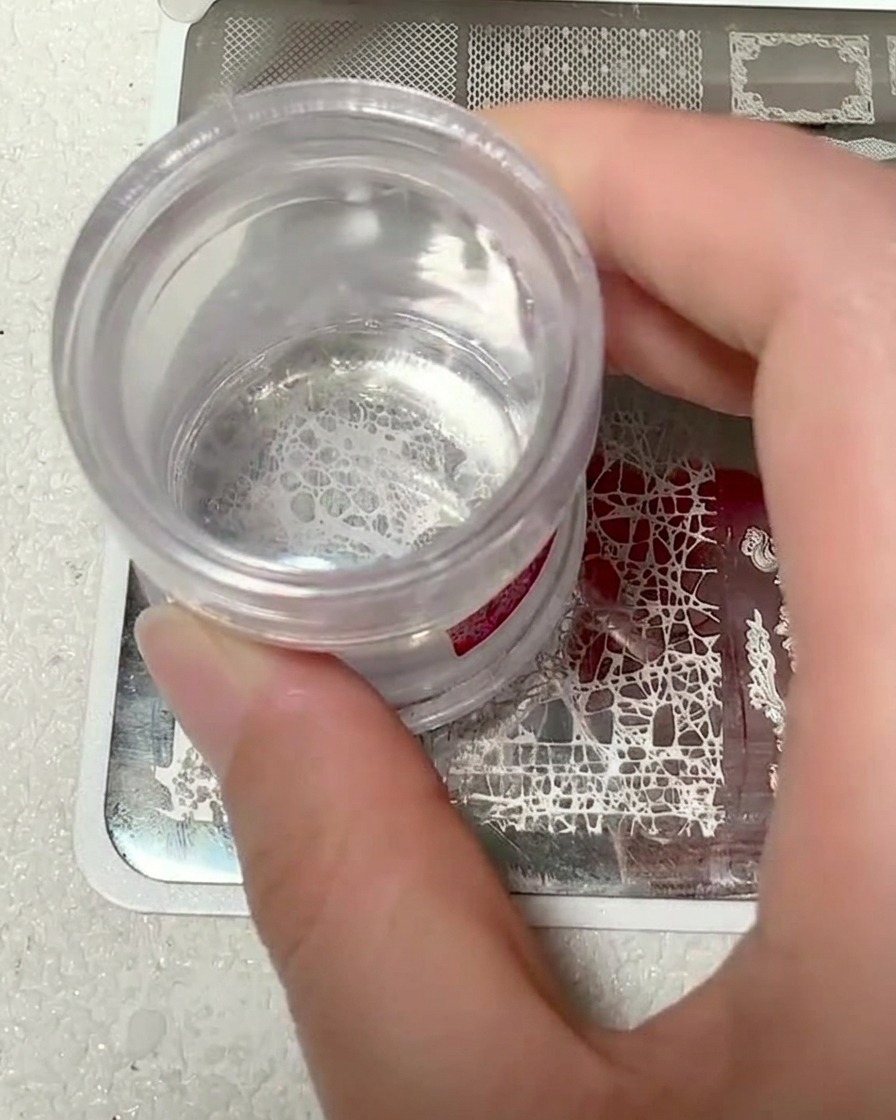 Une tête de tampon en silicone transparent montrant le motif de dentelle blanche ramassé.
