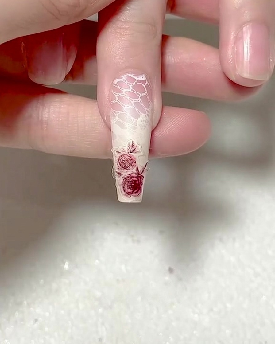 Un outil à embout silicone pressant fermement sur un autocollant rose.