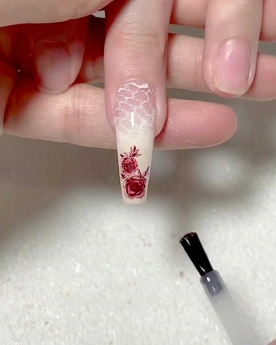 Un pinceau appliquant une couche de top coat mat sur longle.