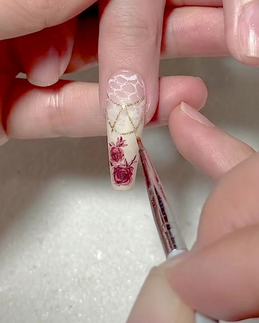 Gros plan dun pinceau liner ajoutant des contours en gel blanc le long dun triangle.