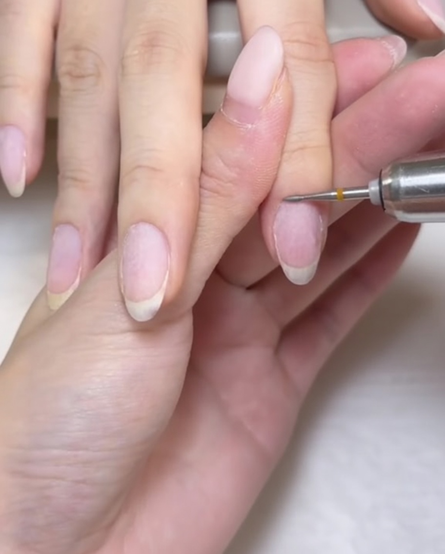 Un petit embout de ponceuse en forme de grain de millet nettoyant avec précision la zone des cuticules.