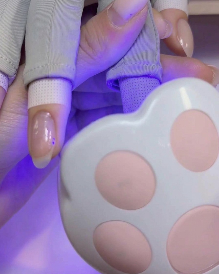 Un pinceau pour nail art appliquant une couche lisse et pigmentée de gel de construction sur longle.