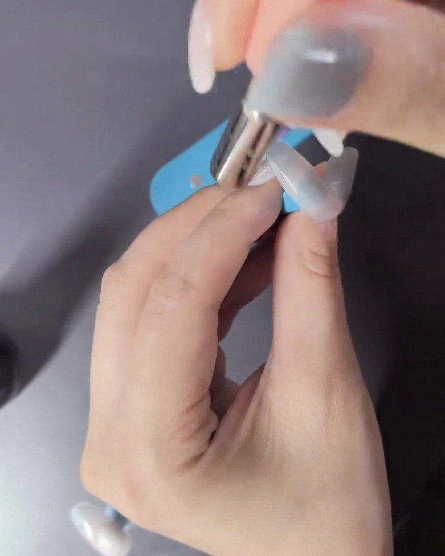 Une main à lintérieur dune lampe LED catalysant le vernis gel cat-eye.