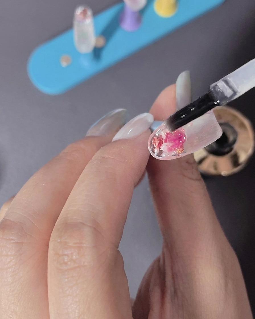 Une main plaçant un ongle sous la lumière dune lampe LED.