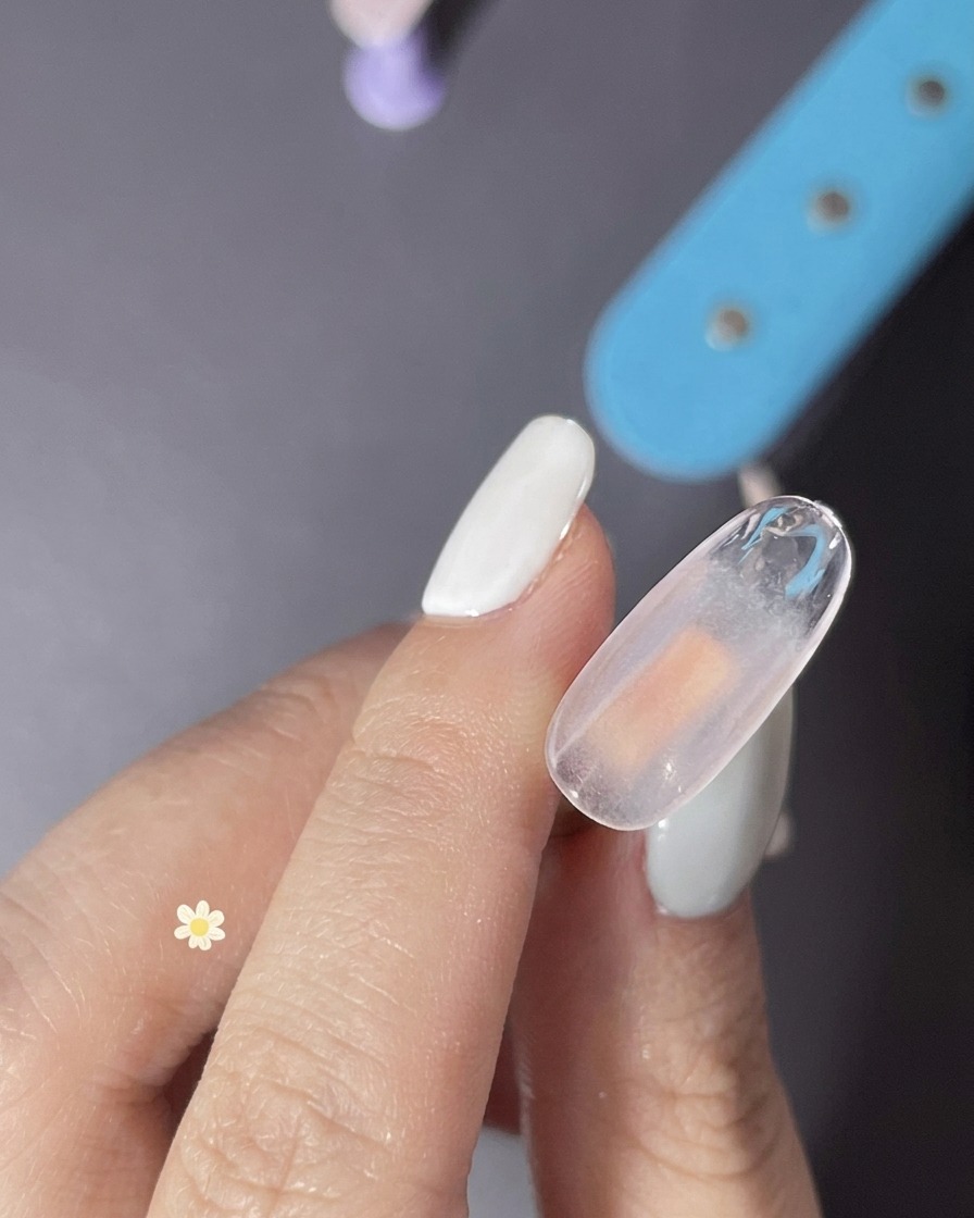 Gros plan dune couche de gel transparent appliquée sur longle pour créer une texture.