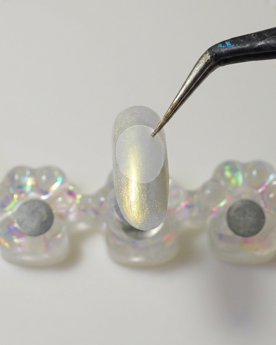 Une spatule métallique appliquant une noisette de gel de construction solide et épais sous un disque en plastique.