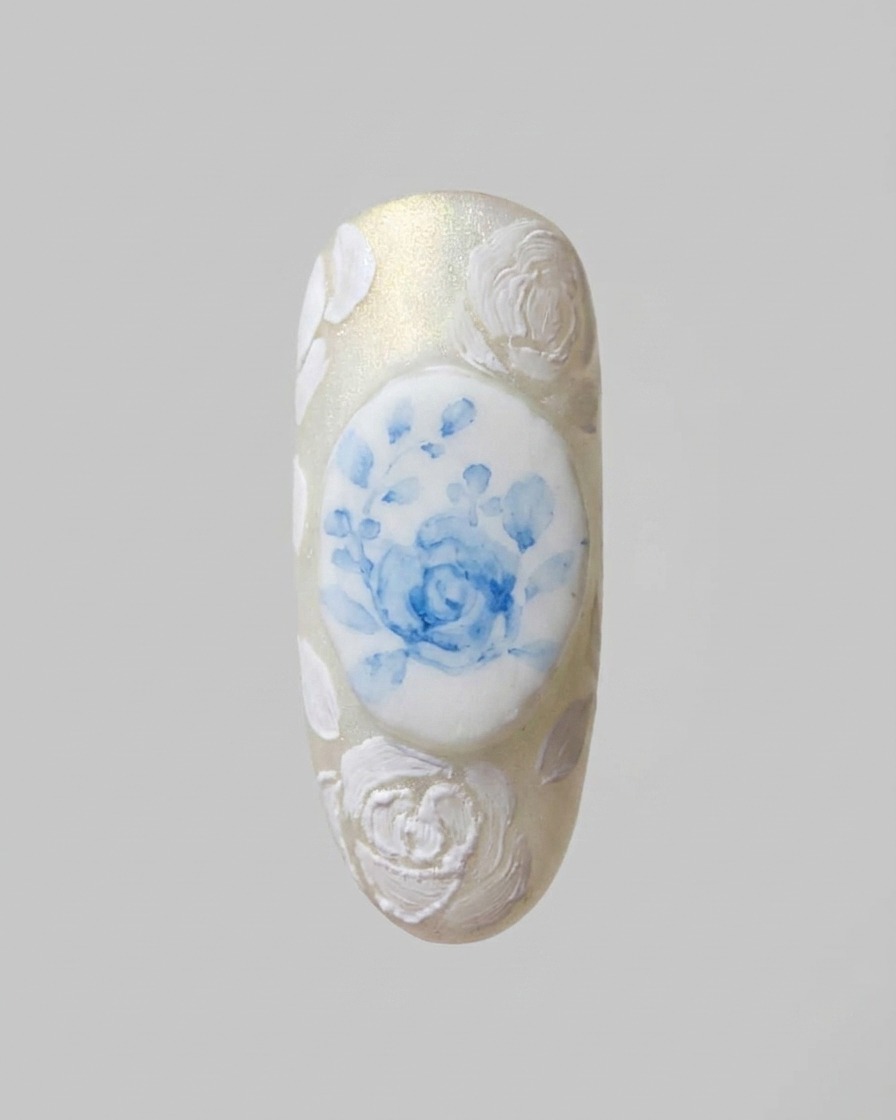 Un pinceau de détail fin ajoutant des motifs de dentelle blanche complexes reliant les designs de roses 3D.