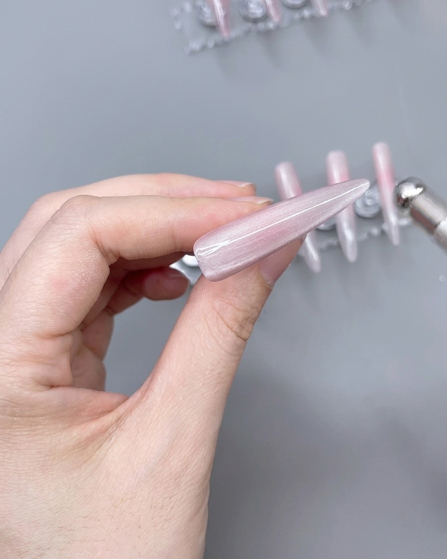 Un aimant positionné au-dessus dune capsule recouverte de gel œil-de-chat pour créer un reflet lumineux.