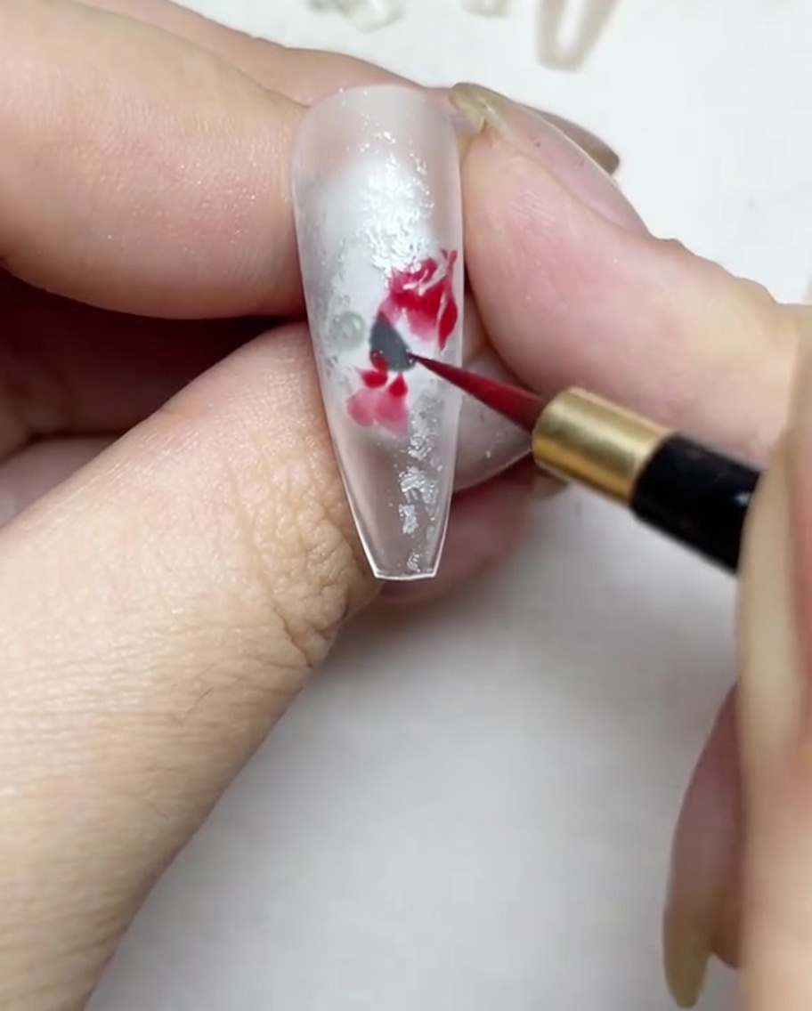 Intensification du centre de la rose aquarelle avec une teinte de rouge plus foncée.