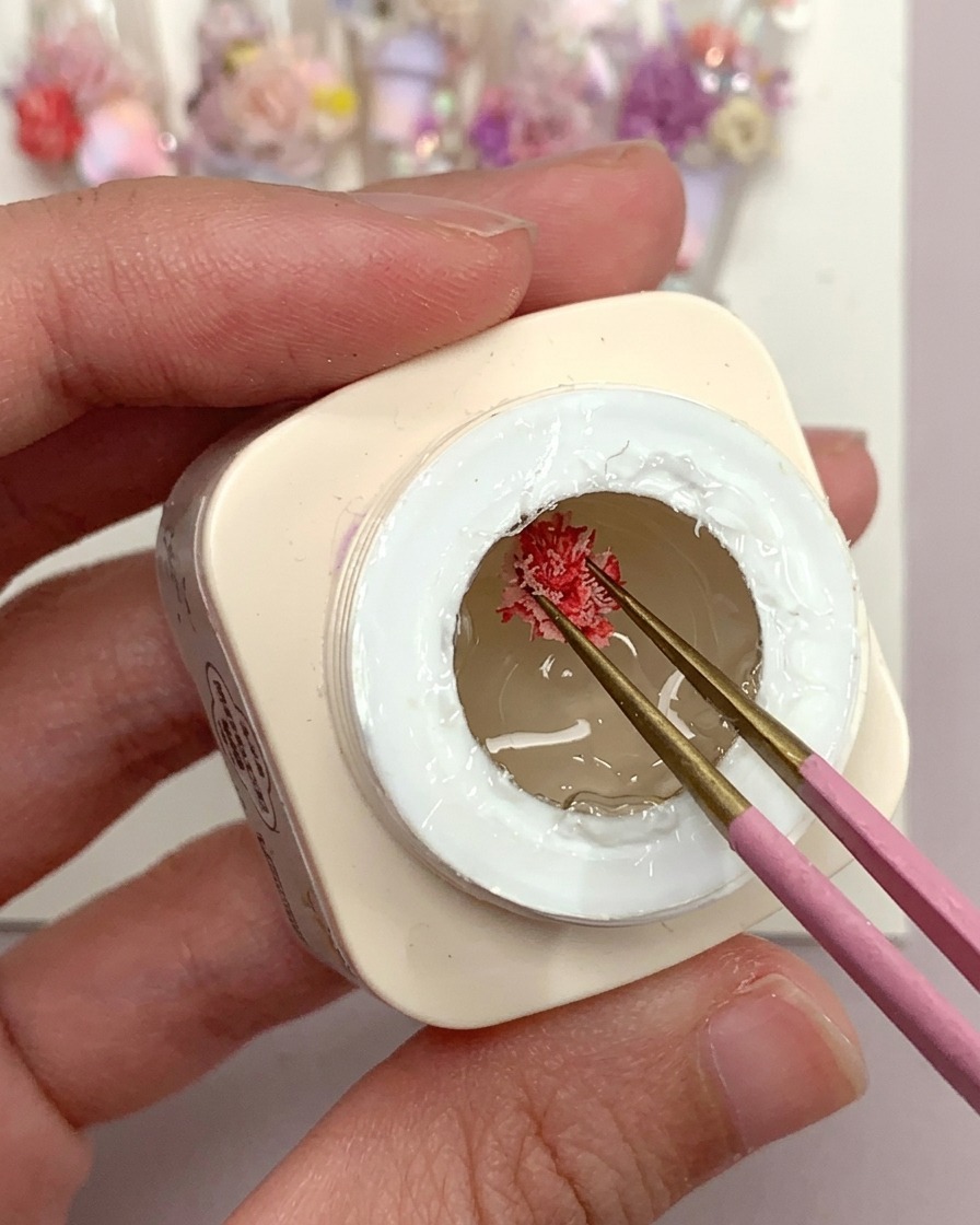 Un pinceau appliquant une goutte de colle gel givrée transparente sur un tip dongle en plastique.
