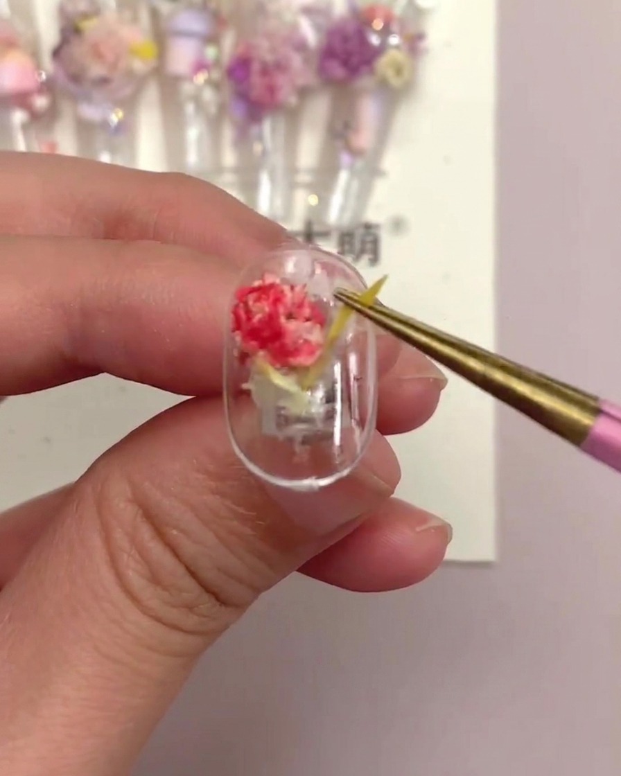 Une pince tirant doucement sur une pièce de fleur linéaire jaune sur un tip fini pour tester sa sécurité.
