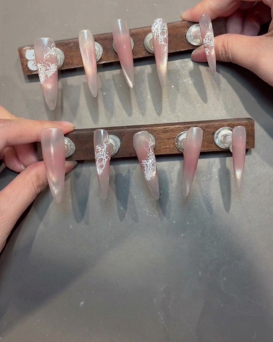 Application dun gel de renforcement transparent sur un ongle décoré de dentelle.