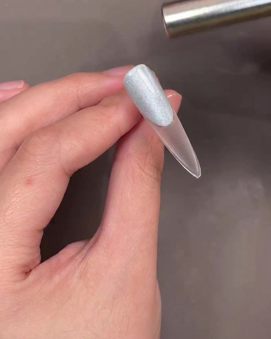 Un aimant cylindrique maintenu au-dessus de longle pour créer le reflet cat-eye.