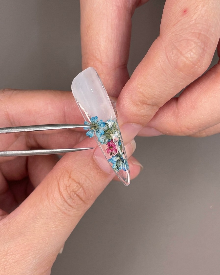 Gros plan sur des strass transparents placés parmi les fleurs séchées sous longle.