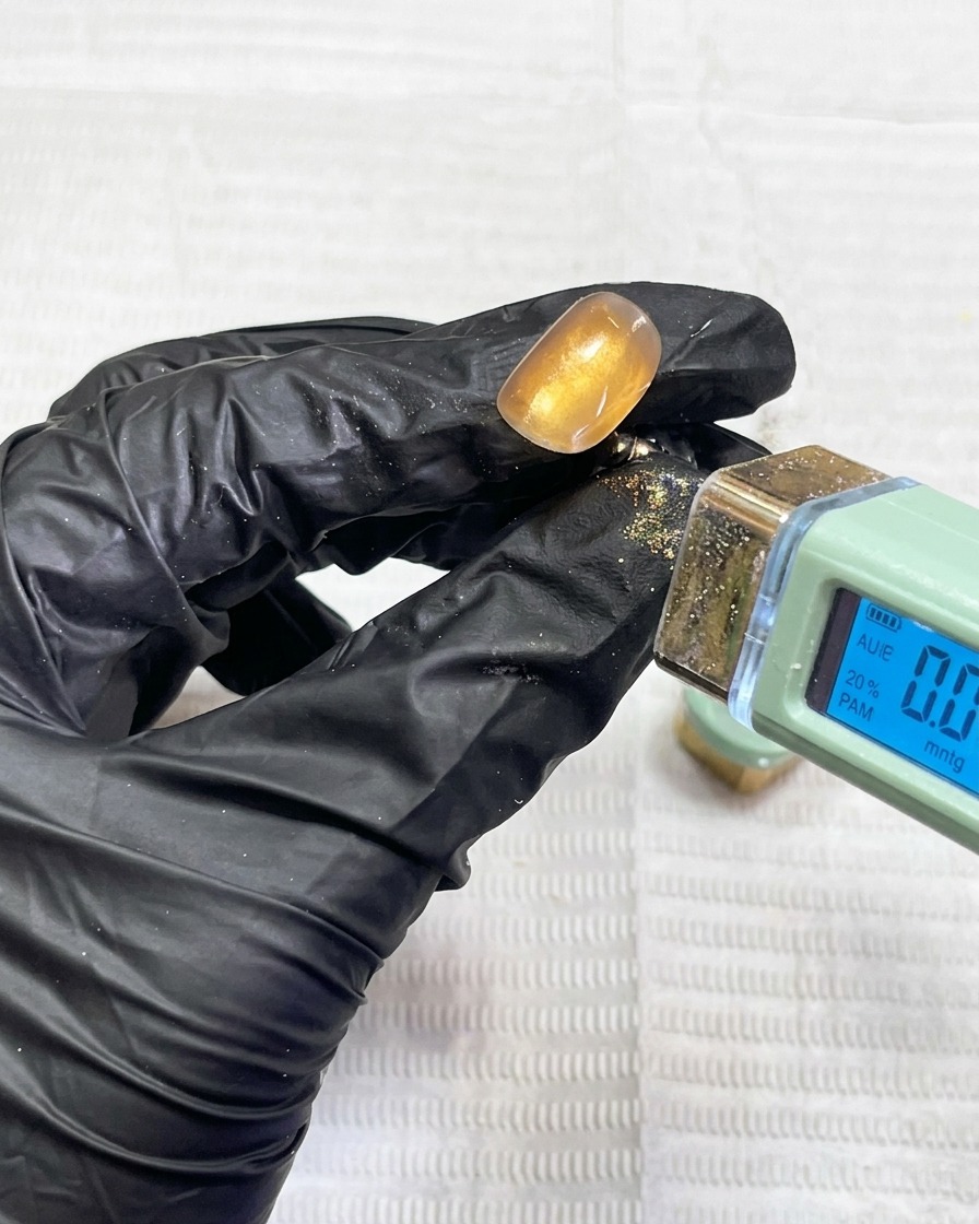 Un ongle catalysant sous une lampe UV professionnelle.