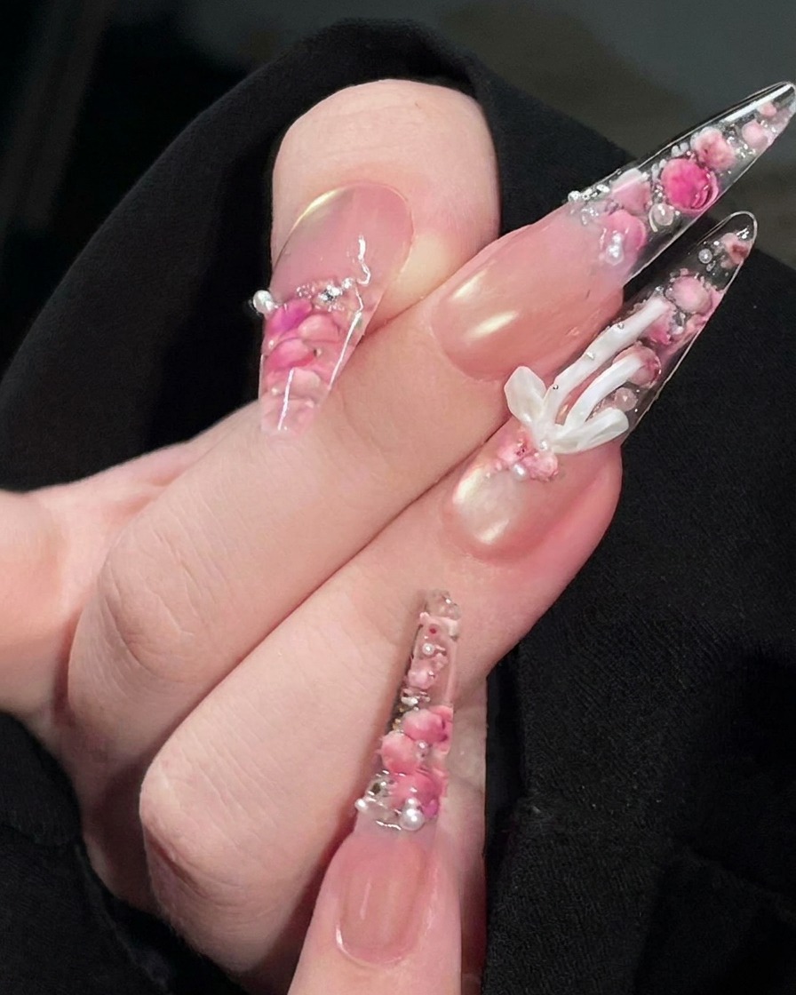 Un pinceau appliquant un top coat transparent et brillant sur la surface du design dongle rose fini.