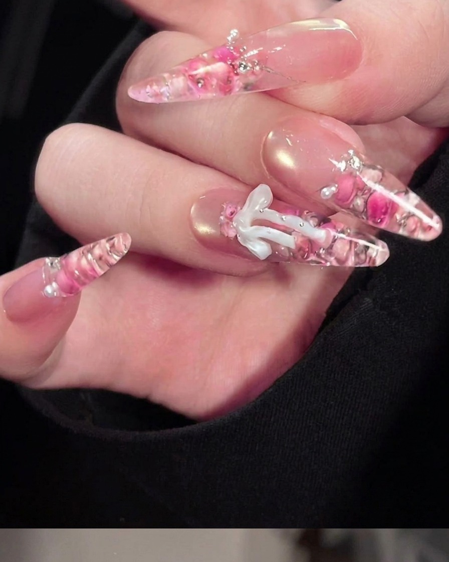 Gros plan dun pinceau fin appliquant des détails en gel blanc sur un nœud 3D en gel préformé.