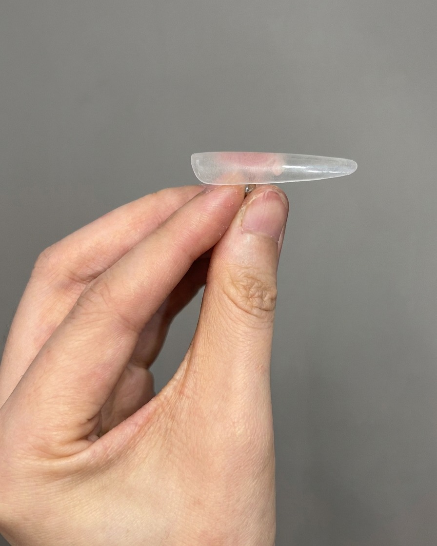 Gros plan sur un outil retirant la fine poussière de la surface dun embout dongle transparent.