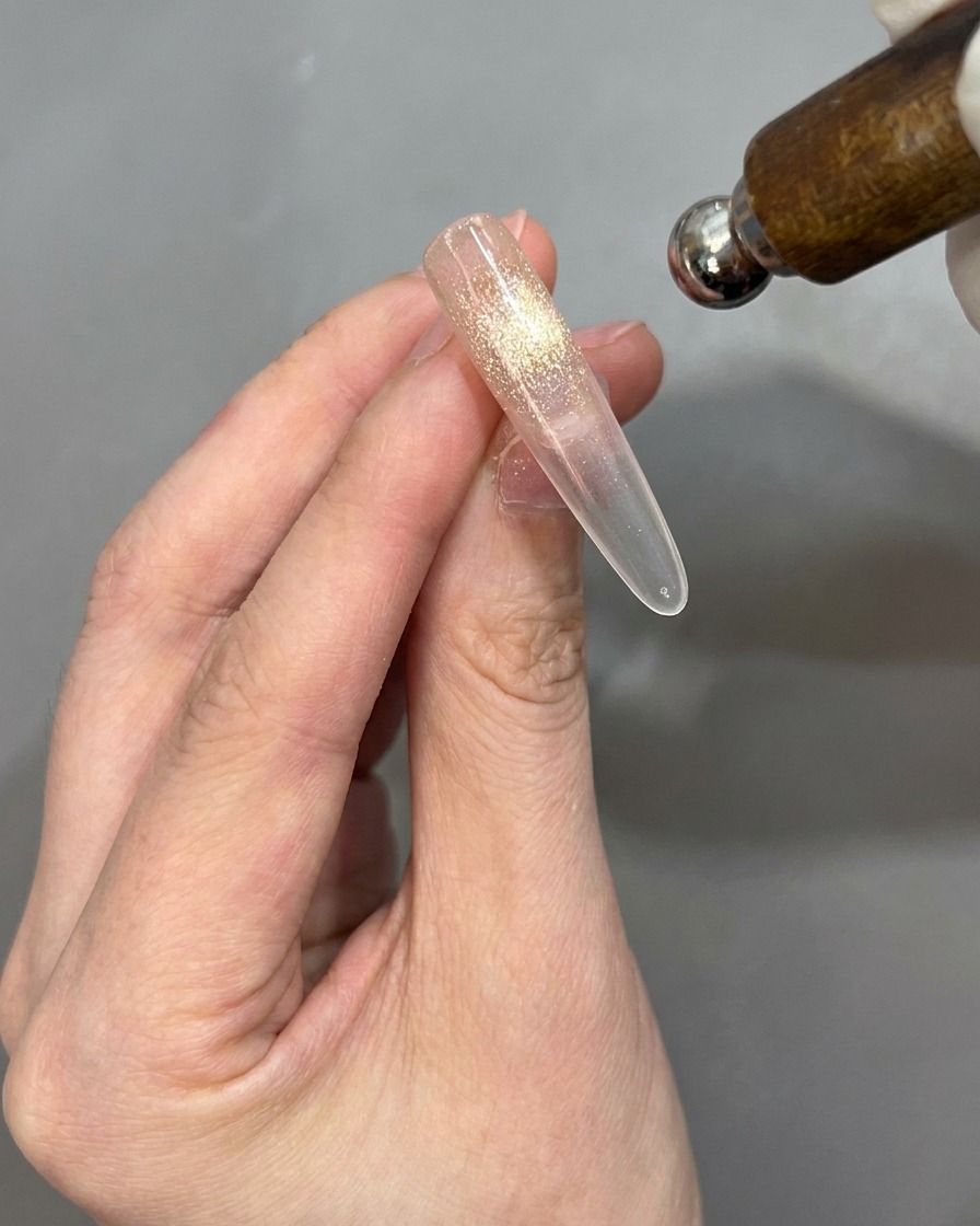 Un aimant placé près dun embout dongle pour activer leffet cat-eye, longle étant positionné pour être retourné.
