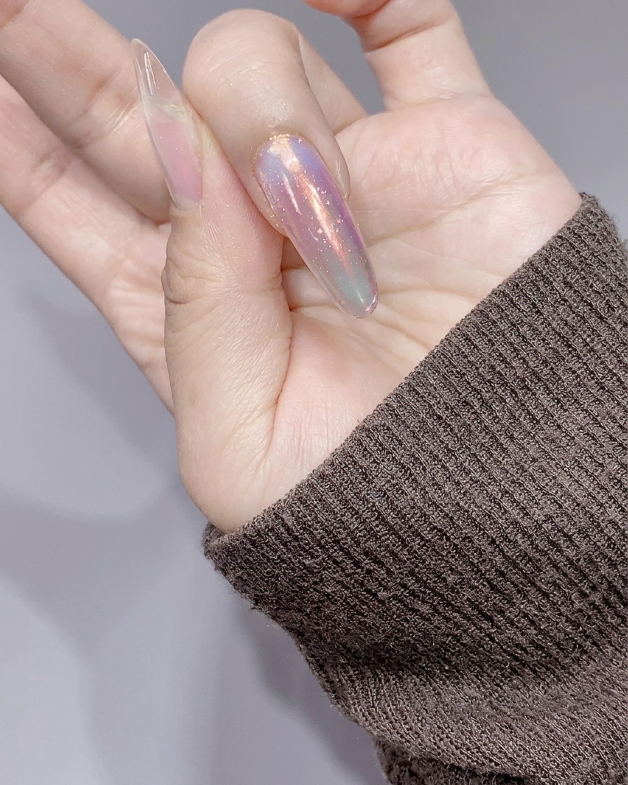 Les ongles catalysés sous une petite lampe UV/LED rose après lapplication du gel pailleté.