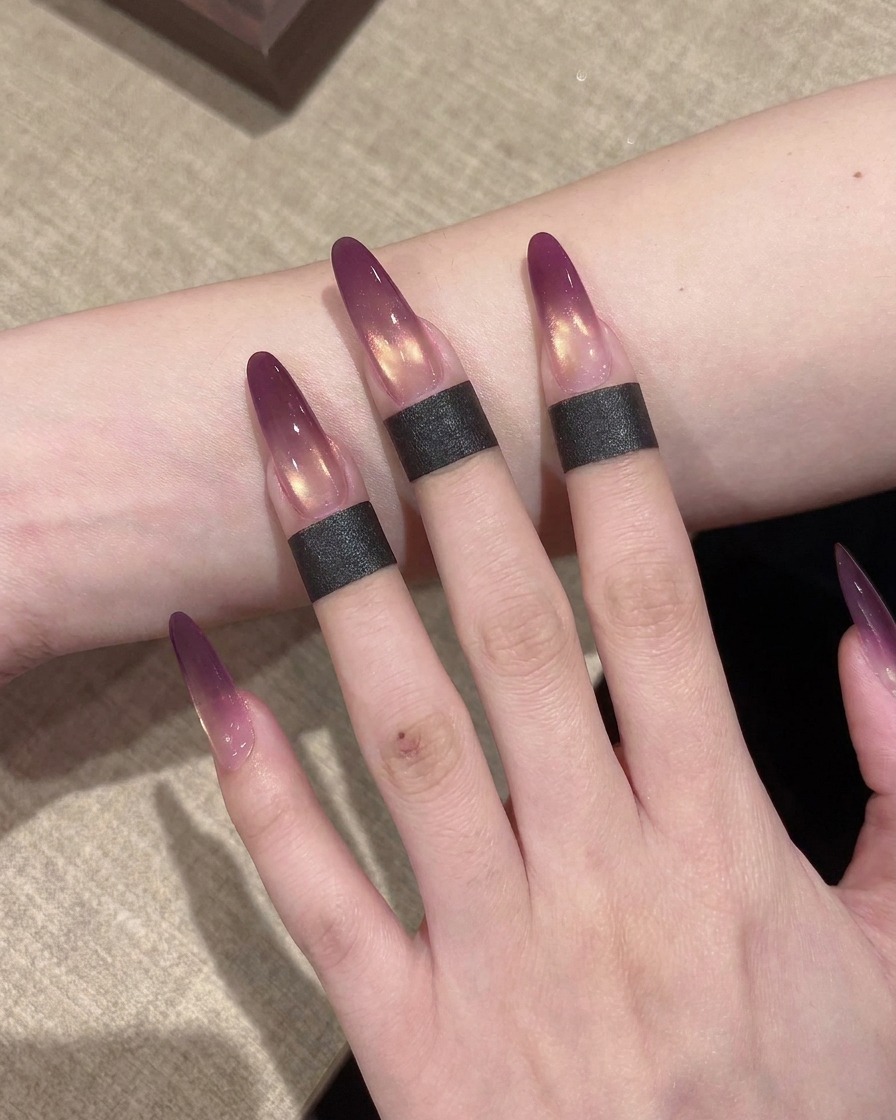 Gros plan montrant une petite éponge de maquillage utilisée pour tapoter et estomper le gel violet sur lextension afin de créer un effet ombré.