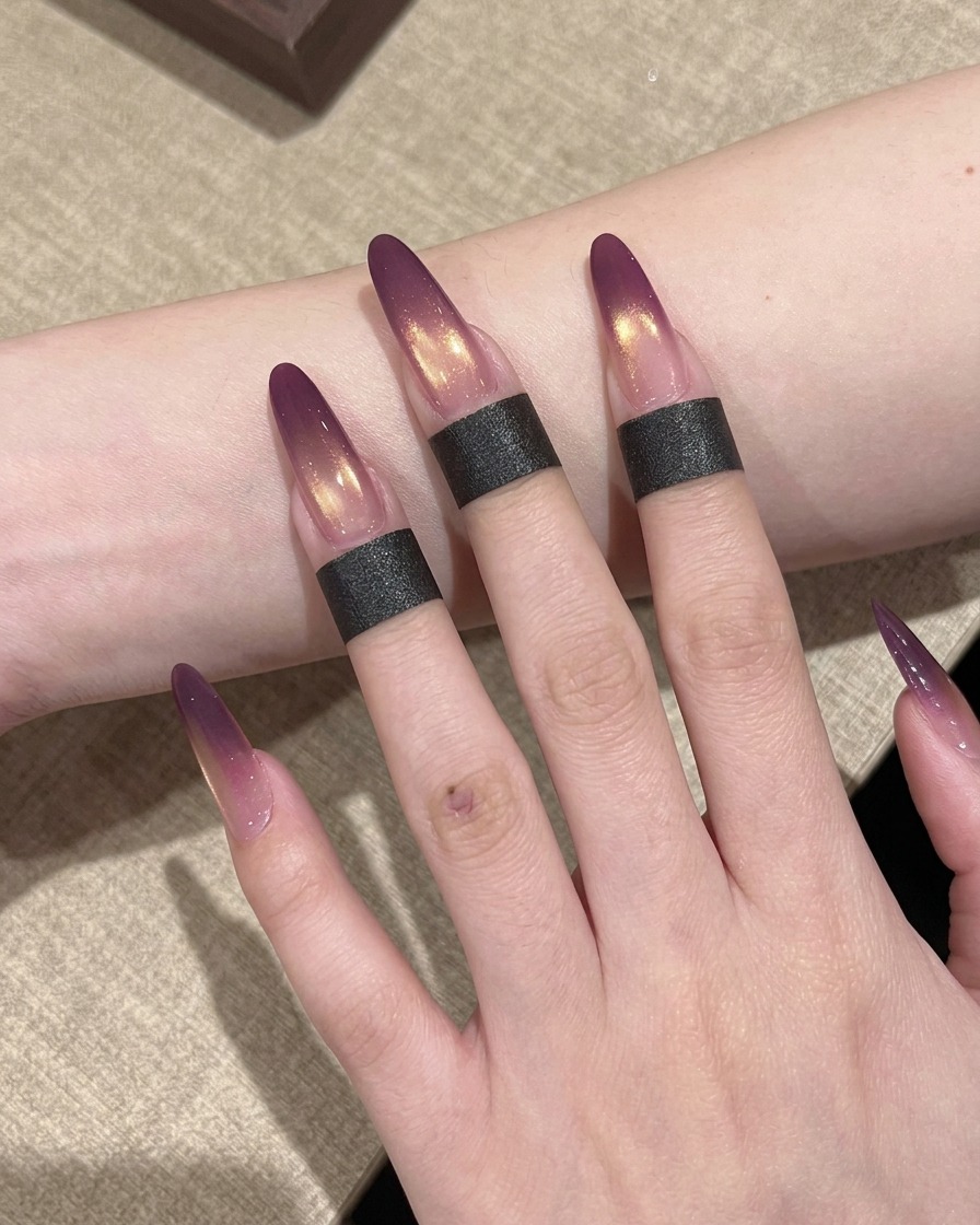 Une main avec des ongles dégradés positionnée dans une lampe UV professionnelle pour catalyse.