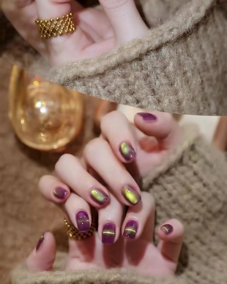 Un pinceau à vernis appliquant une couche de finition brillante sur les ongles œil-de-chat violet et or.