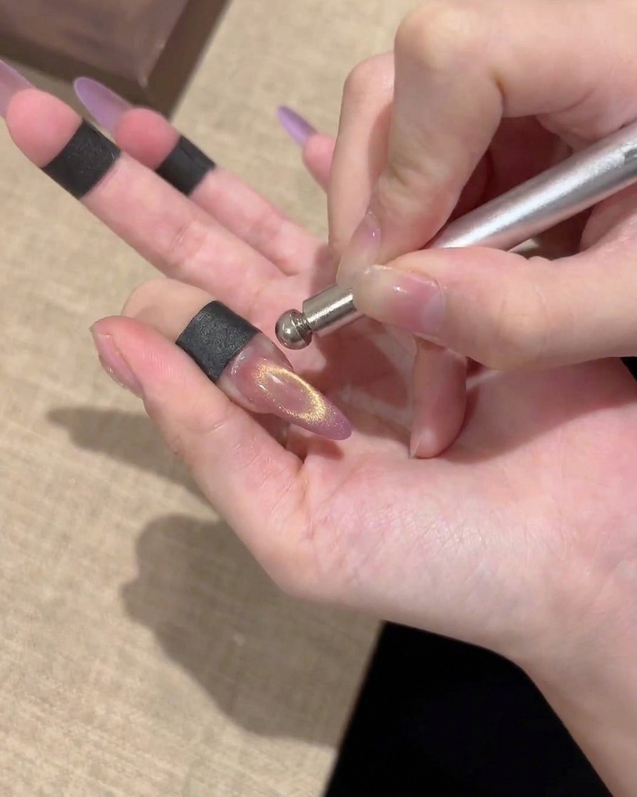 Gros plan dun ongle cat-eye magnétique fini montrant un reflet doré brillant centré.
