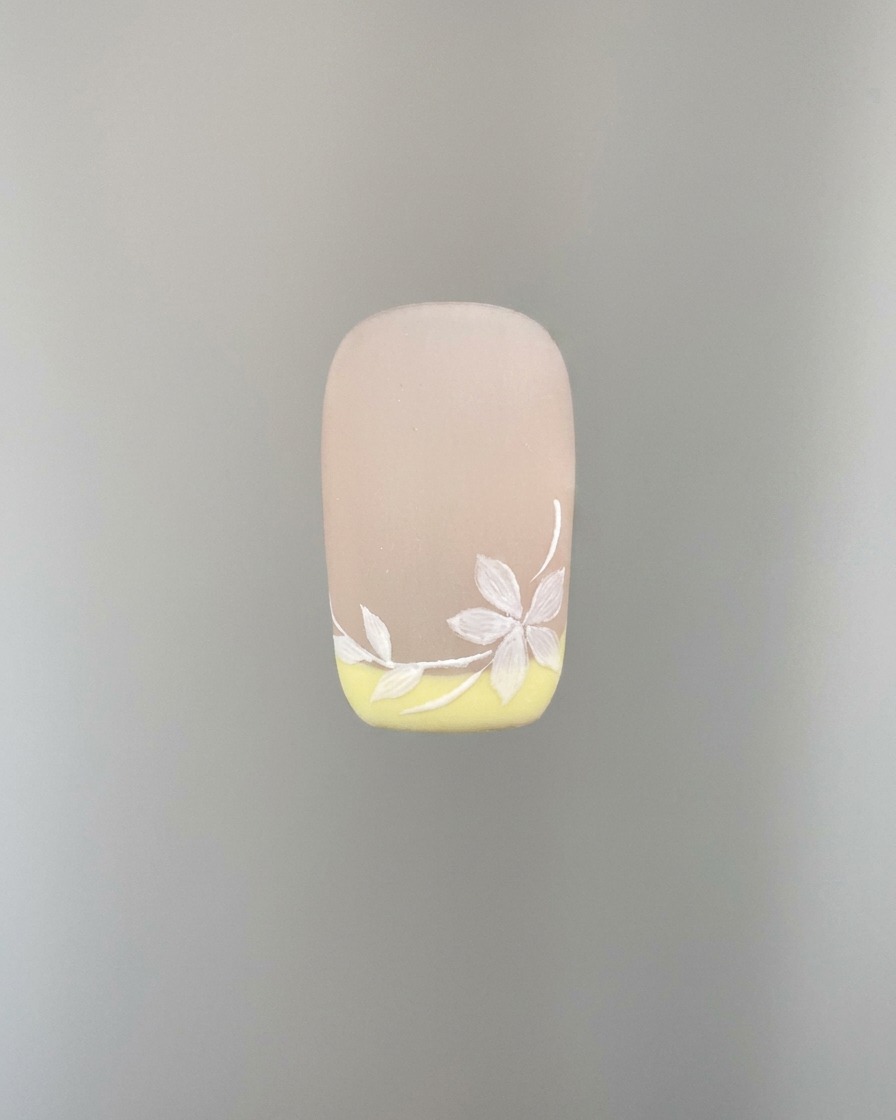 Vue détaillée de lajout de pétales blancs supplémentaires sur le nail art.