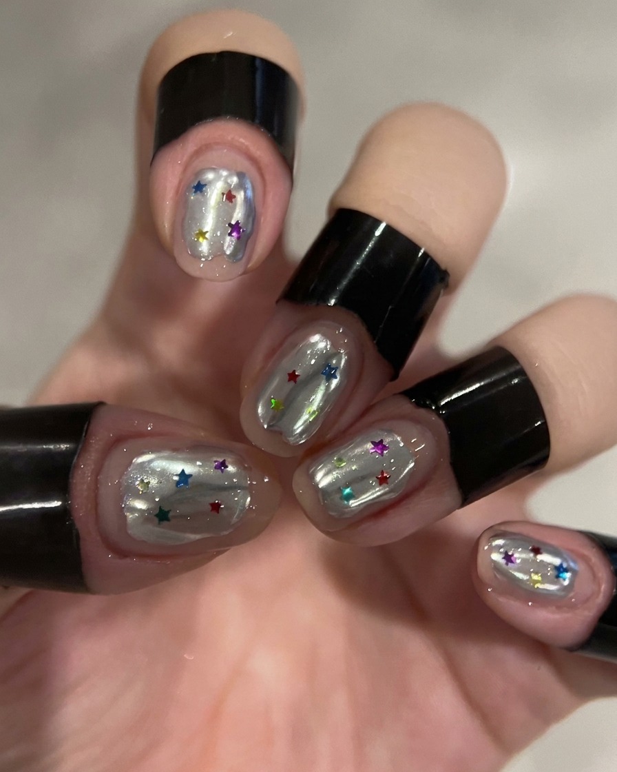 Un dotting tool plaçant des sequins colorés en forme détoile sur le gel de construction dun ongle.