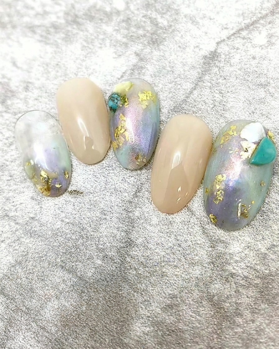 De minuscules morceaux déclats de coquillage blanc appliqués sur un design dongles comme décoration.