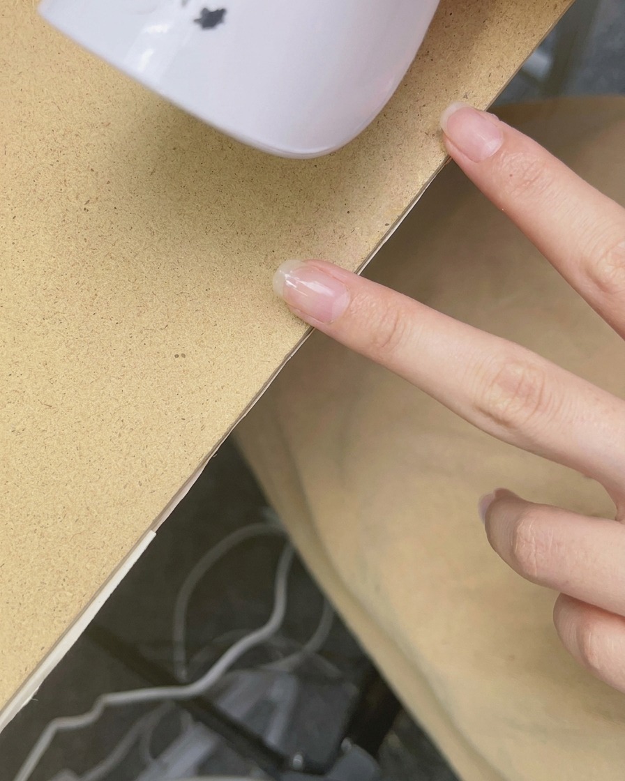 Une mini lampe UV/LED portative maintenue au-dessus dun ongle pour catalyser le vernis.
