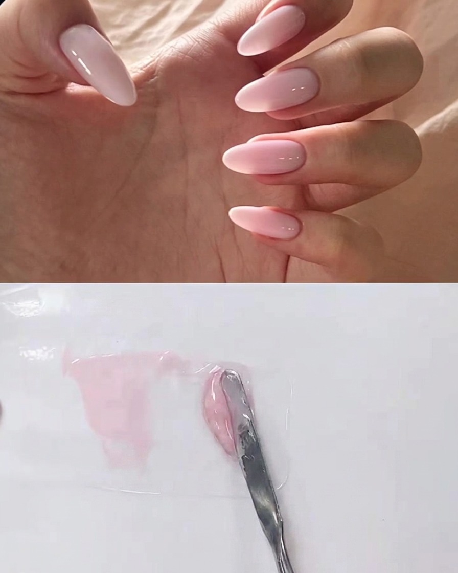 Une spatule en métal mélangeant du gel transparent dans une base rose sur une palette.