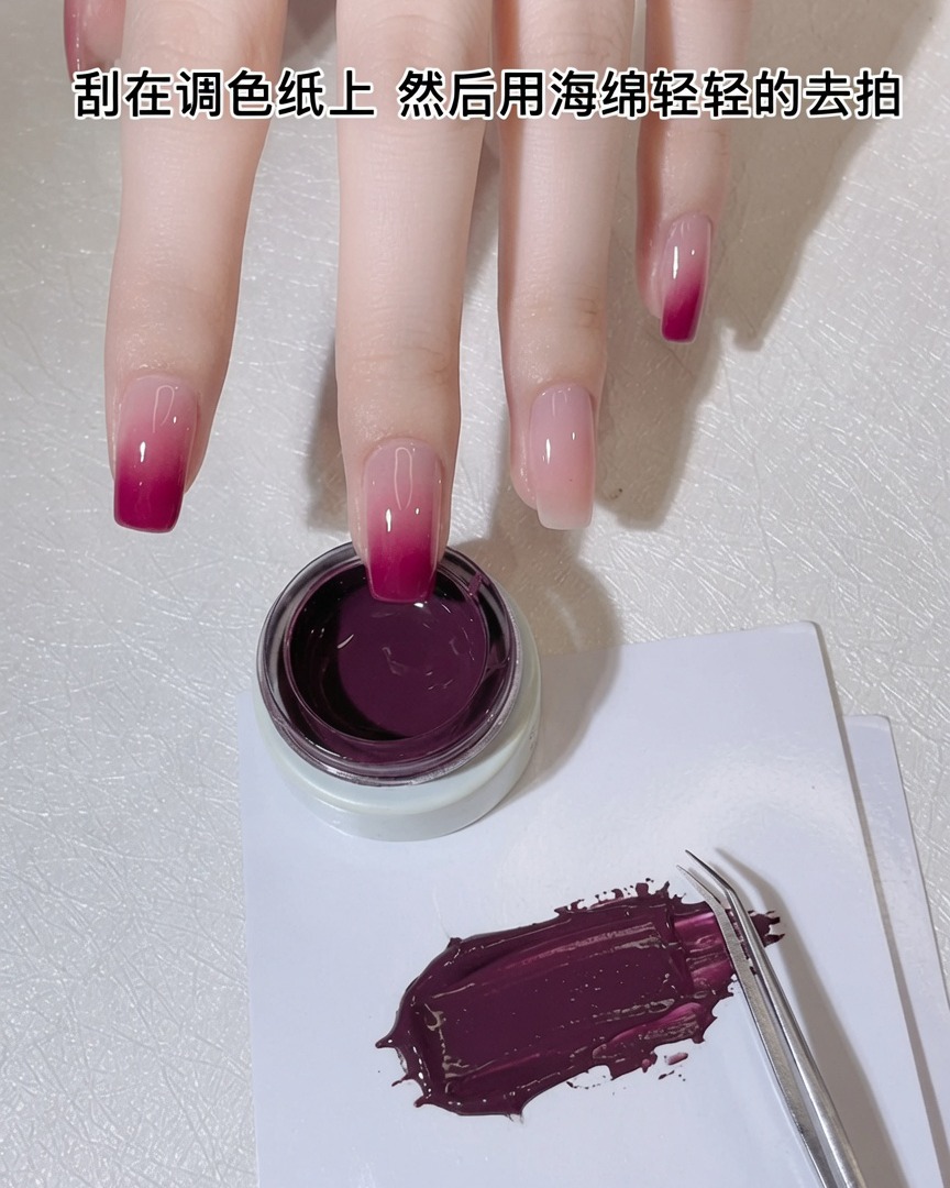 Une éponge à maquillage blanche pressée dans une fine couche de gel rose violacé sur une palette.