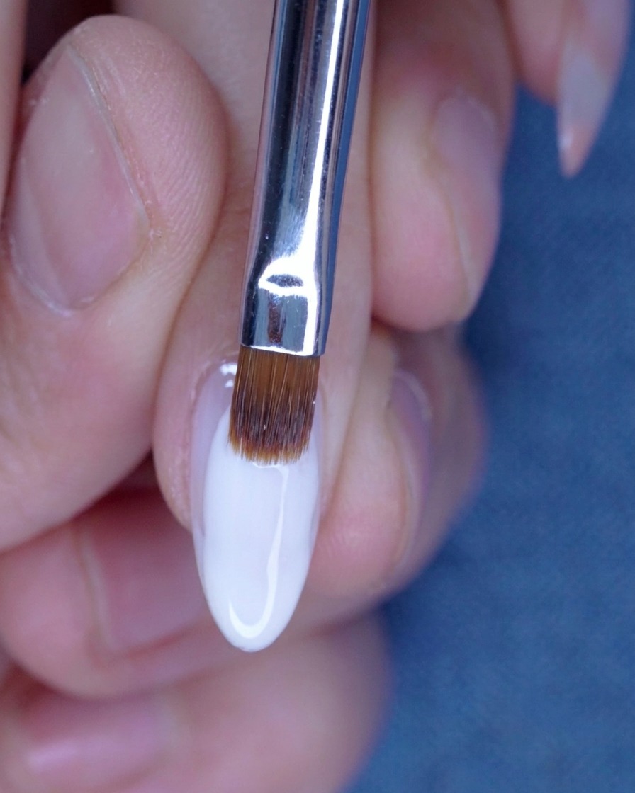 Estompage de la seconde couche de gel nude avec un pinceau pour une transition parfaite.