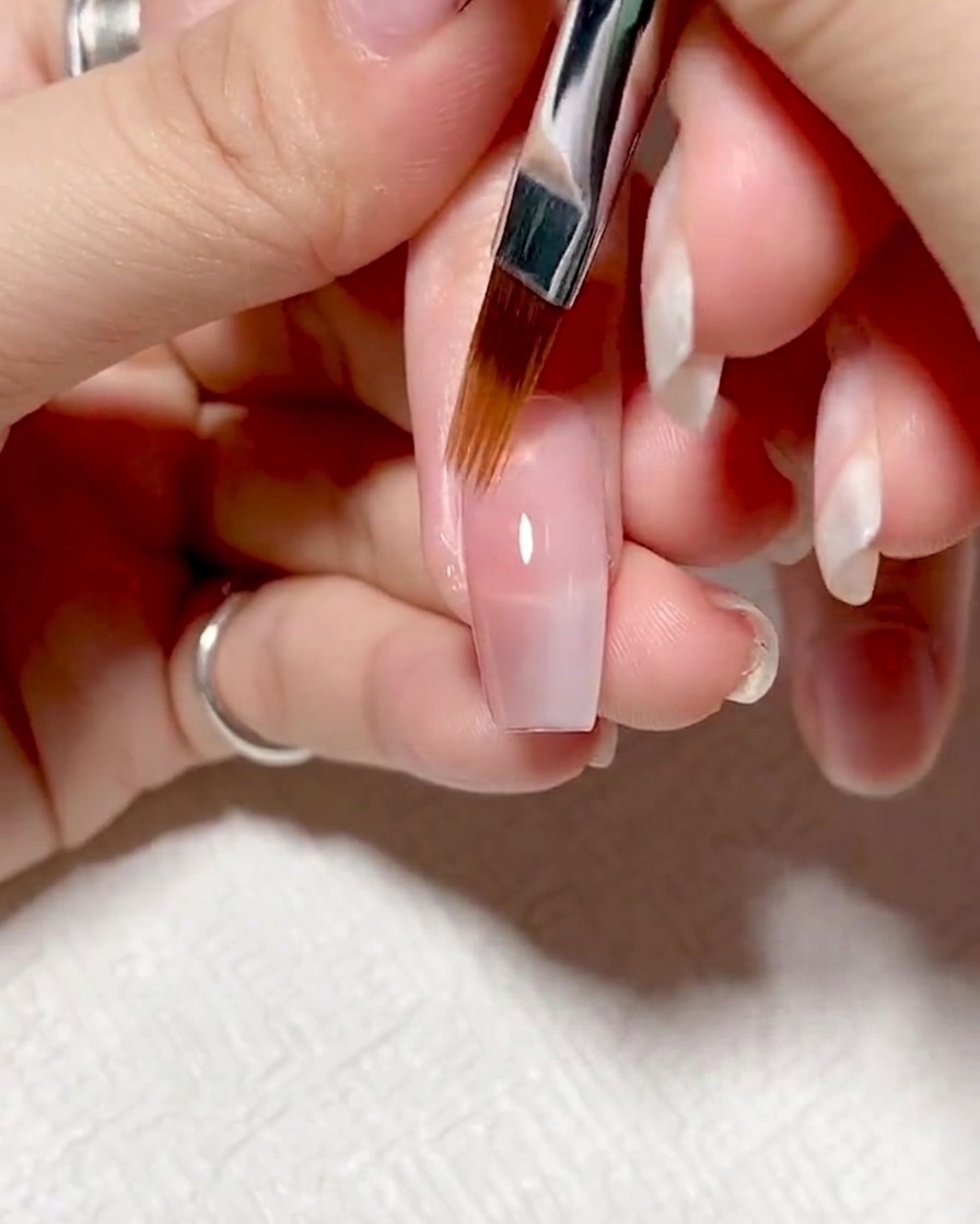 Ongles sous une lampe UV/LED en cours de catalysation.