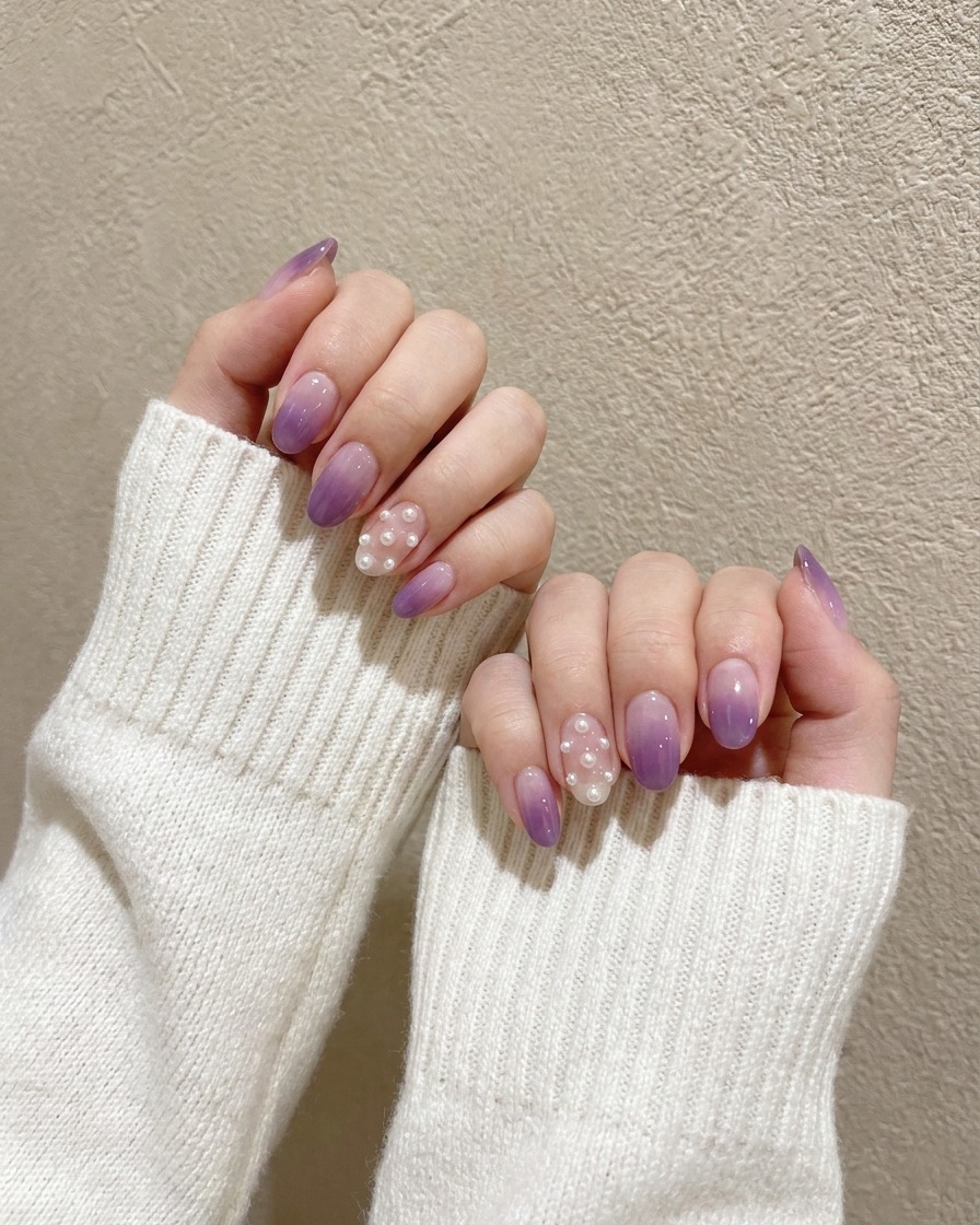 Un pinceau de précision tapotant un gel violet foncé sur le bout dun ongle préalablement vernis en violet clair.