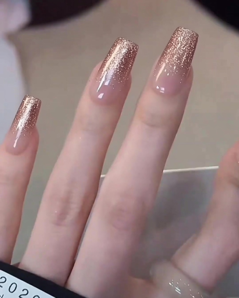 Gros plan dun pinceau appliquant du vernis gel blanc laiteux concentré sur le bout dun ongle naturel.