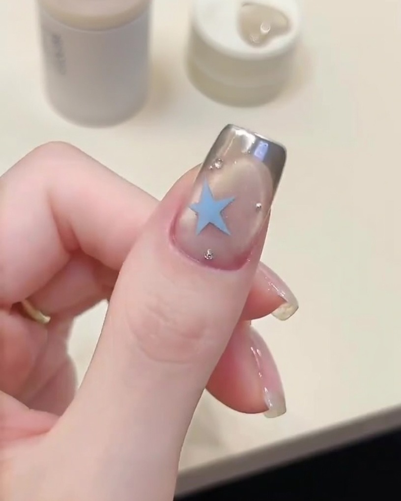 Un pinceau appliquant une couche de base gel transparente sur un ongle préparé.