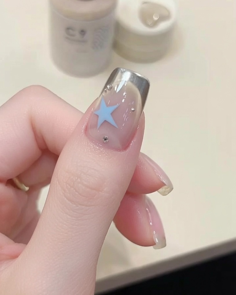 Un pinceau appliquant un top coat transparent brillant sur un ongle.